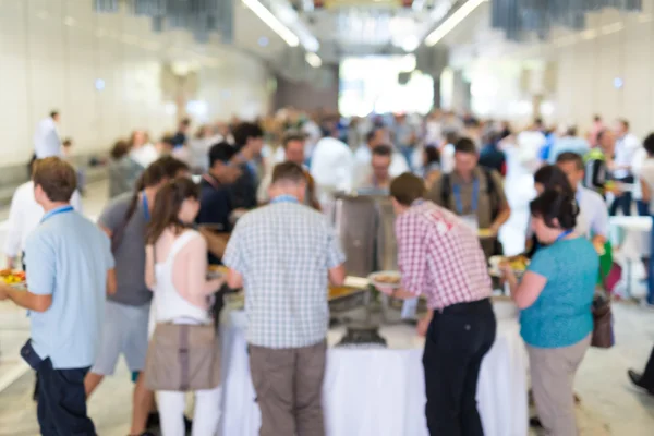 Samenvatting wazig mensen socialiseren tijdens lunchpauze op zakelijke conferentie. — Stockfoto