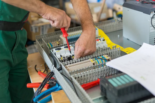 Electricista armando gabinete eléctrico industrial . — Foto de Stock