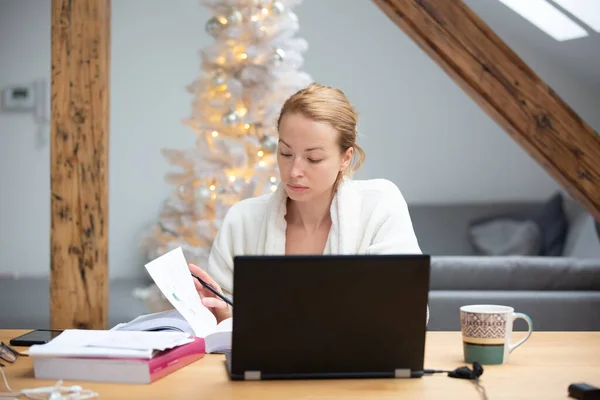 Jeune femme entrepreneure portant un peignoir chaud confortable travaillant à distance de la maison en hiver période de Noël pendant 2020 pandémie de virus corona. Travail à domicile, selter en place, concept. — Photo