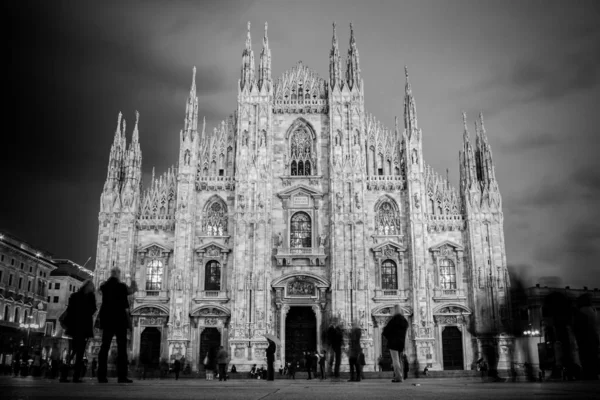 De Dom van Milaan (Italiaans: "Duomo di Milano") is de kathedraal van Milaan. Neergeschoten in de schemering van het plein vol mensen. — Stockfoto