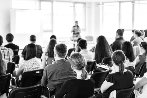 Relatore che tiene un discorso nella sala conferenze in occasione di un evento di business meeting. Vista posteriore di persone irriconoscibili in platea nella sala conferenze. — Foto Stock