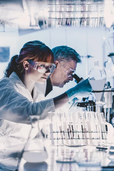 Investigadores sanitarios que trabajan en laboratorio científico. — Foto de Stock