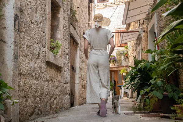 Rückansicht der schönen blonden jungen Reisenden mit Strohhut Sightseeing und genießen Sommerurlaub in einer alten traditionellen Küstenstadt an der Adria, Kroatien — Stockfoto