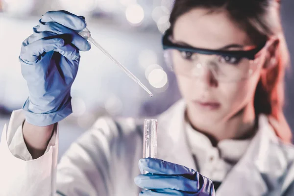 Junge Wissenschaftlerin pipettiert im Life Science Labor. — Stockfoto