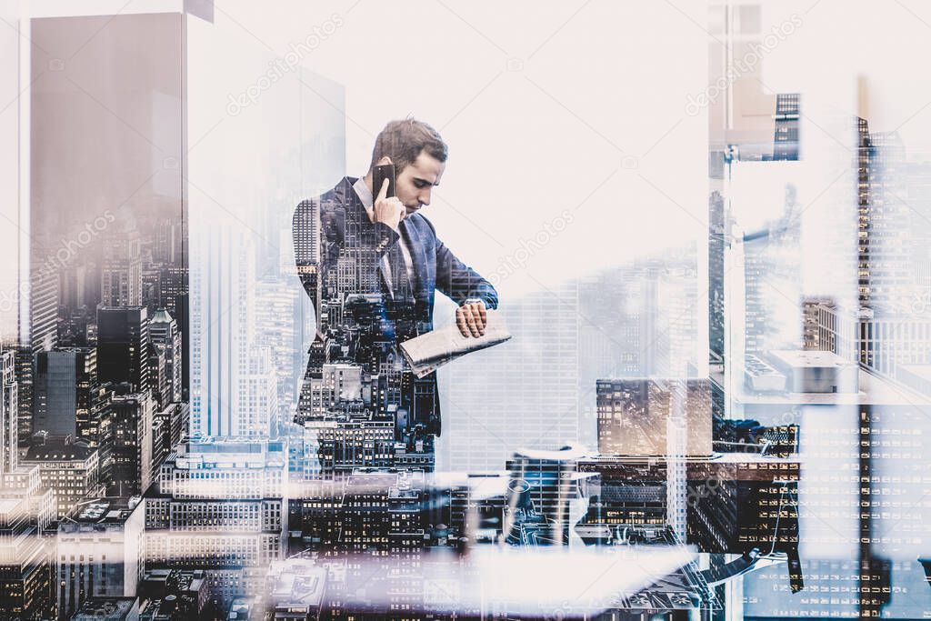 Businessman talking on mobile phone while looking at wristwatch.