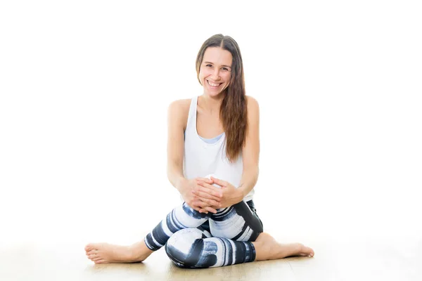 Jovem esportivo instrutor de ioga feminino no estúdio de ioga branco brilhante, sorrindo alegremente, olhando para a câmera. — Fotografia de Stock