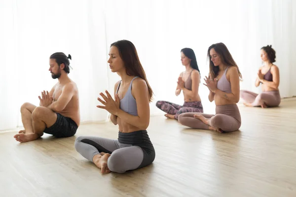 Grupo de jovens autênticos desportivos pessoas atraentes no estúdio de ioga, praticando aula de ioga com instrutor. Estilo de vida ativo saudável, exercitando-se no ginásio — Fotografia de Stock