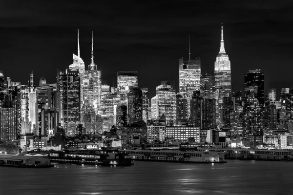 West New York City midtown Manhattan skyline panorama view from Boulevard East Old Glory Park over Hudson River at night. Black and white image.