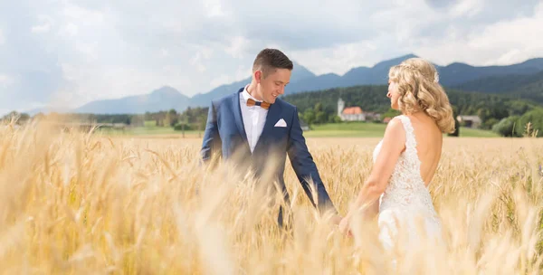 Mariée tenant la main dans un champ de blé quelque part dans la campagne slovène. — Photo