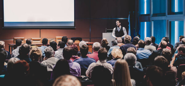 Бизнес-спикер выступает с докладом на мероприятии деловой конференции.