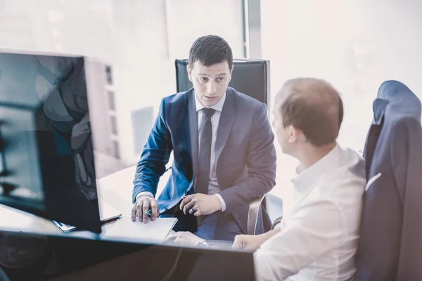 Två affärsmän diskuterar ett bisiness problem vid möte i handel kontor. — Stockfoto