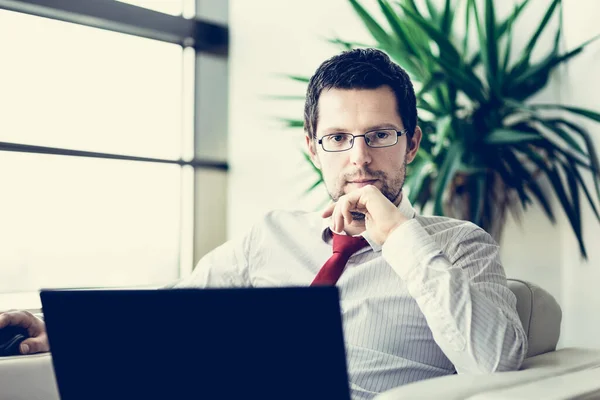 Porträt eines Geschäftsmannes, der am Laptop arbeitet — Stockfoto