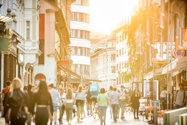 Copovan kävelykadulla Ljubljanassa on hämärää porukkaa auringonlaskun aikaan. Kaupunkien elämäntapa ja liikkuvuus. — kuvapankkivalokuva