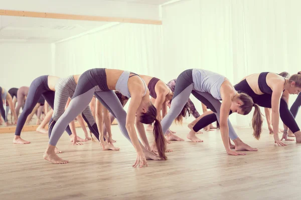 Groep van jonge authentieke sportieve aantrekkelijke mensen in yoga studio, het beoefenen van yoga les met instructeur. Gezonde actieve levensstijl, sporten in de sportschool — Stockfoto