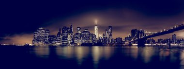 Manhattan Köprüsü ve New York Şehri gökdelenleri Doğu Nehri panoramasını aydınlatan gökdelenlerle dolu..