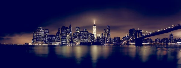 Manhattan Bridge i Nowy Jork w nocy z drapaczami chmur oświetlonymi nad panoramą East River. — Zdjęcie stockowe