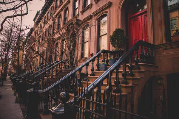 Row of old brownstone buildings along an empty sidewalk block in the Greenwich Village neighborhood of Manhattan, New York City NYC — Stock Photo, Image