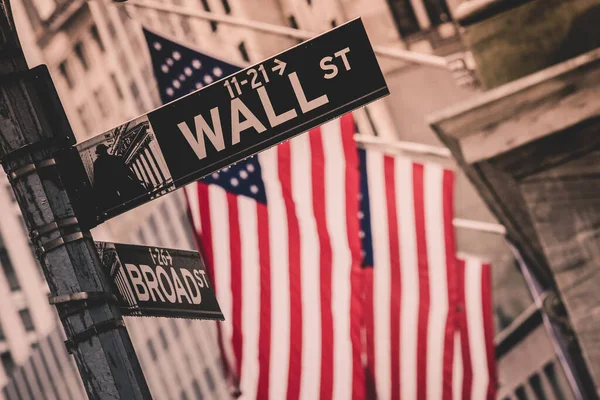 Wall Street sign di New York dengan bendera Amerika dan New York Stock Exchange di latar belakang — Stok Foto