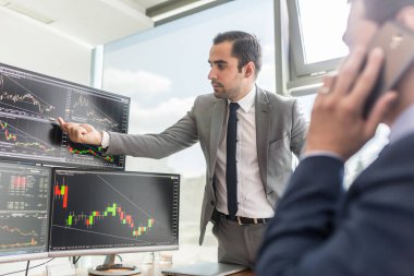 Borsacılar bilgisayar ekranlarına bakıyor, çevrimiçi ticaret yapıyorlar..