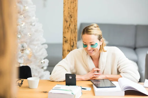 Joven empresaria vestida con albornoz cálido y acogedor que trabaja remotamente desde casa en invierno en época de Navidad durante la pandemia del virus corona 2020. Trabajo desde casa, selector en su lugar, concepto. — Foto de Stock