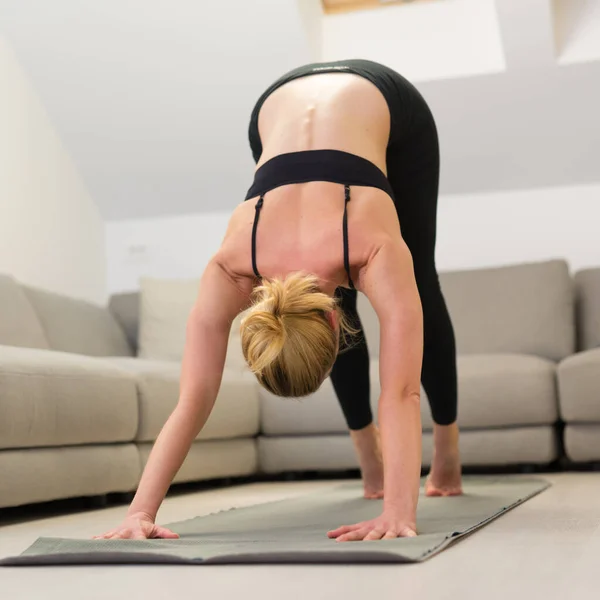 Piękna blondynka ćwicząca w domu. Kobieta ćwiczy jogę w domu. Fit girl za pomocą samouczków treningu dla zdrowego aktywnego stylu życia. Kobieta stosująca kwarantannę do treningu w domu. — Zdjęcie stockowe