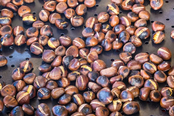 Grilling chestnuts. — Stock Photo, Image