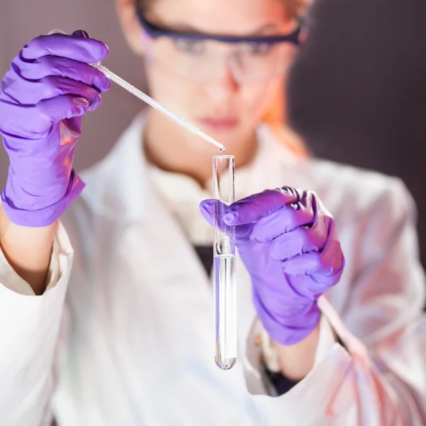 Atraente jovem cientista pipetagem. — Fotografia de Stock