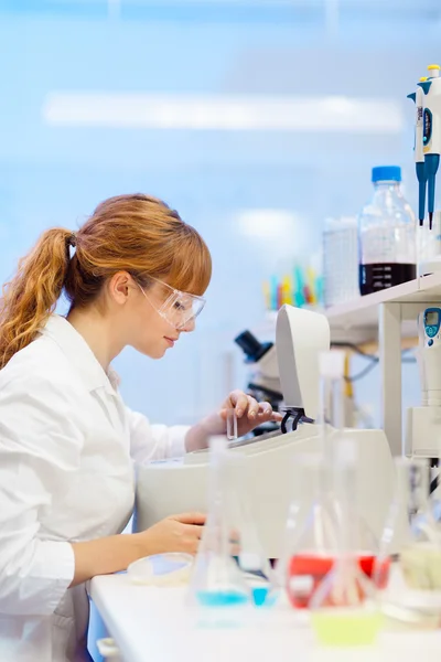Attractive young scientist pipetting. — Stock Photo, Image