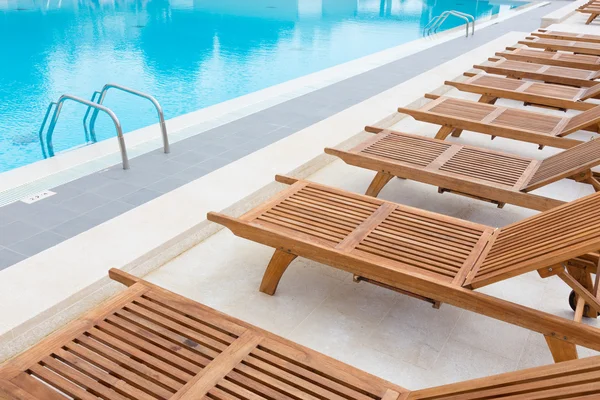 Piscina con tumbonas de madera . — Foto de Stock