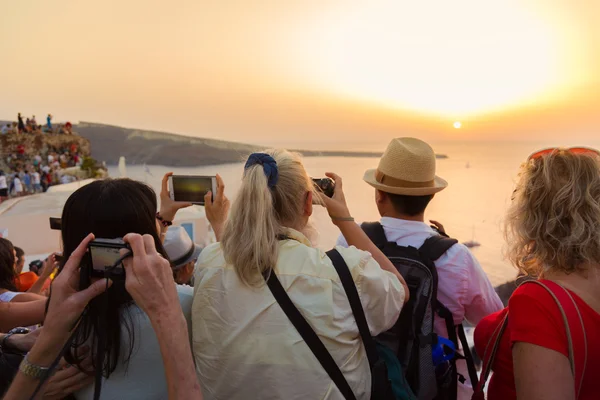 Trvellers kijken naar zonsondergang in Oia, Santorini, Griekenland. — Stockfoto
