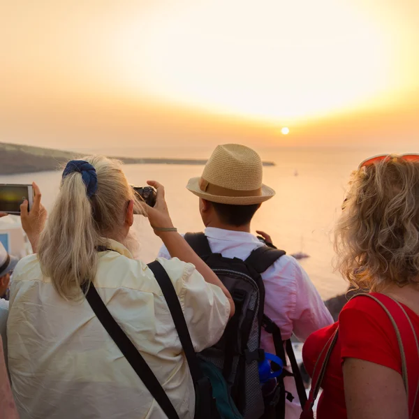 Trvellers sledování západu slunce v Oia Santorini, Řecko. — Stock fotografie