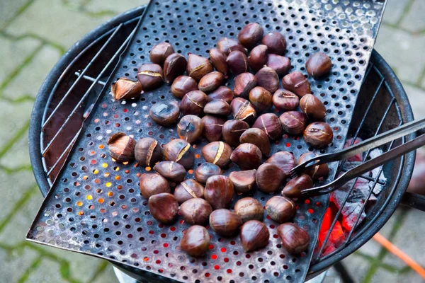 Grilling chestnuts. — Stock Photo, Image