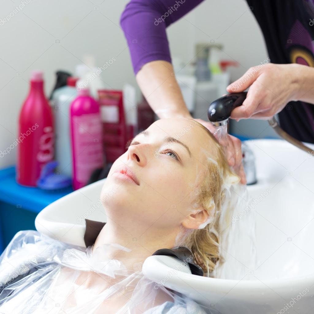 Hairdresser salon. Woman during hair wash.