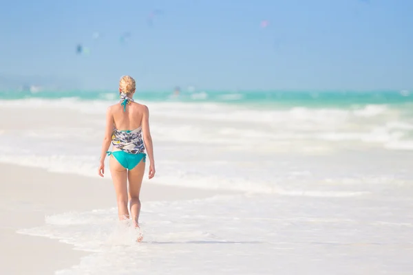 Žena, které běží na pláži v západu slunce. — Stock fotografie