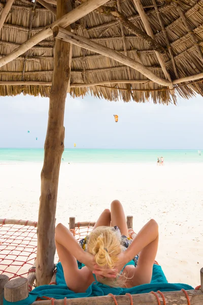 Mulher tomando banho de sol na praia tropical . — Fotografia de Stock