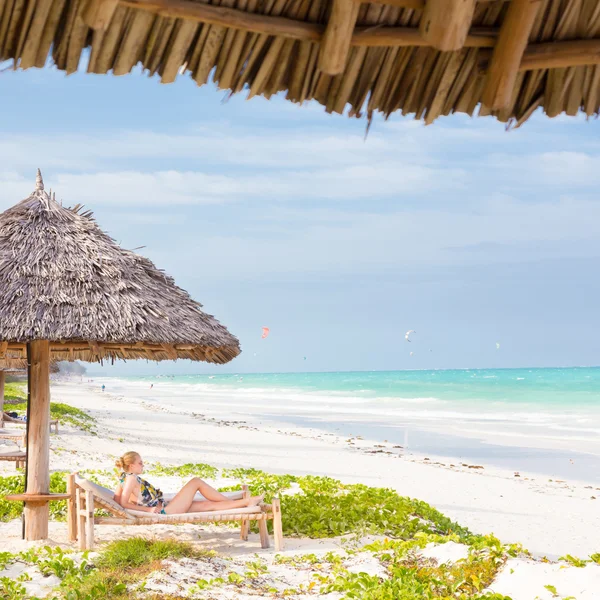 Mujer tomando el sol en la playa tropical . — Foto de Stock