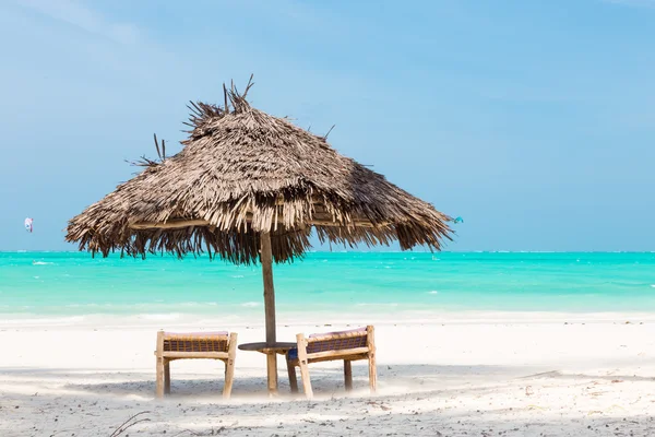 Twee ligstoelen en parasol op tropisch strand. — Stockfoto