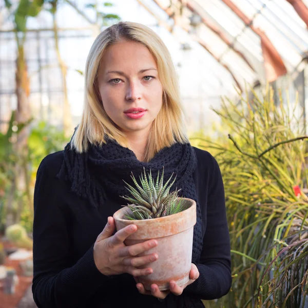 Florists woman working in greenhouse.