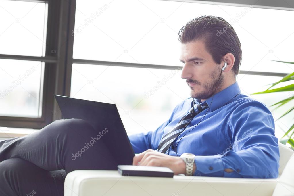 Businessman in office working on his laptop.