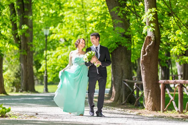 Весільна пара гуляє в парку . — стокове фото