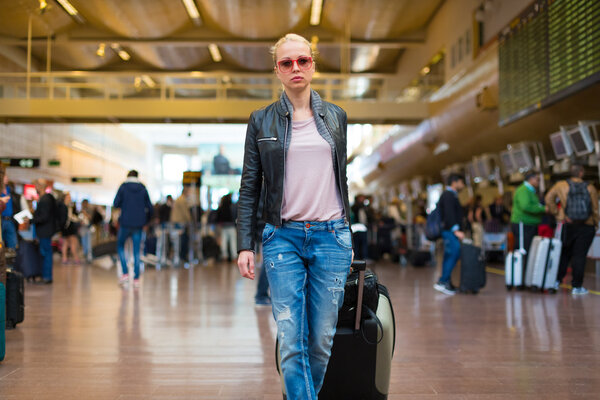 Female traveller walking airport terminal.