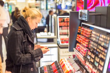 金发美女测试和购买化妆品的美容店güzel kadın güzellik mağaza alışveriş.