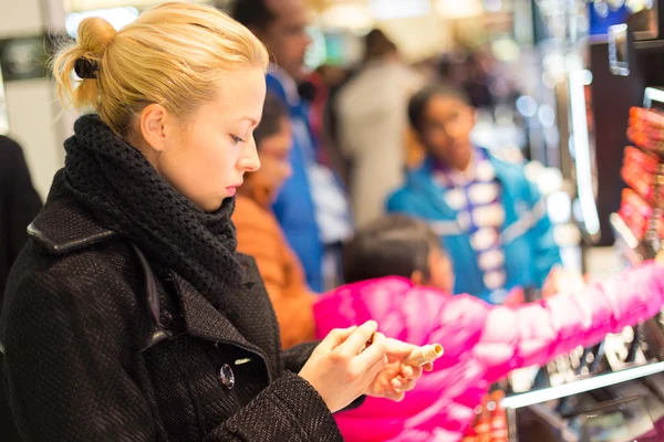 Vacker kvinna shopping i skönhet store. — Stockfoto