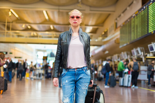 Female traveller walking airport terminal.