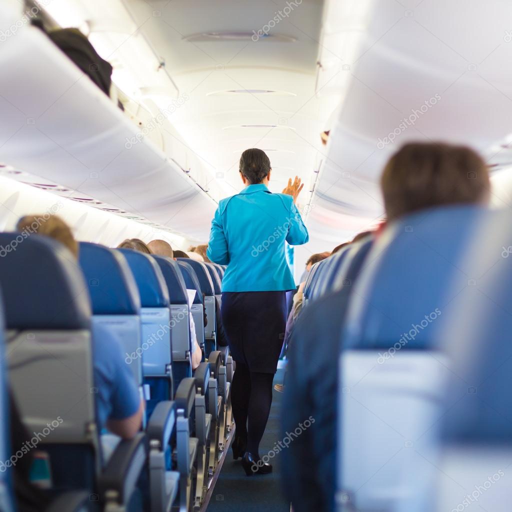 Interior of airplane with passengers on seats.