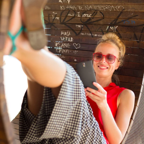 Young cheerful woman using smarthphone. — Stock Photo, Image