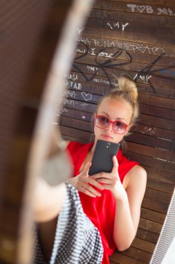 Smarthphone kullanan genç neşeli kadın.