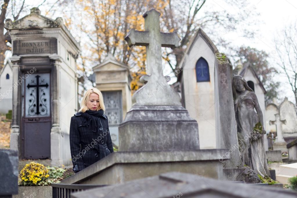 Solitary woman visiting relatives grave.