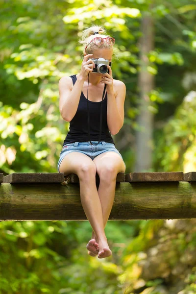 Žena v přírodě s retro fotoaparát. — Stock fotografie