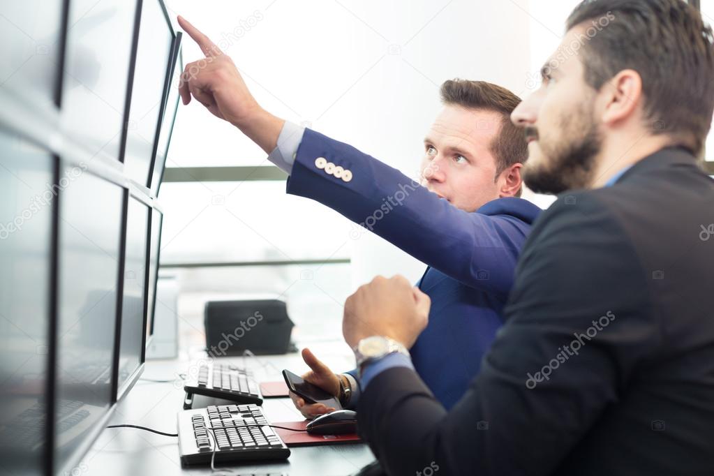 Stock traders looking at computer screens.